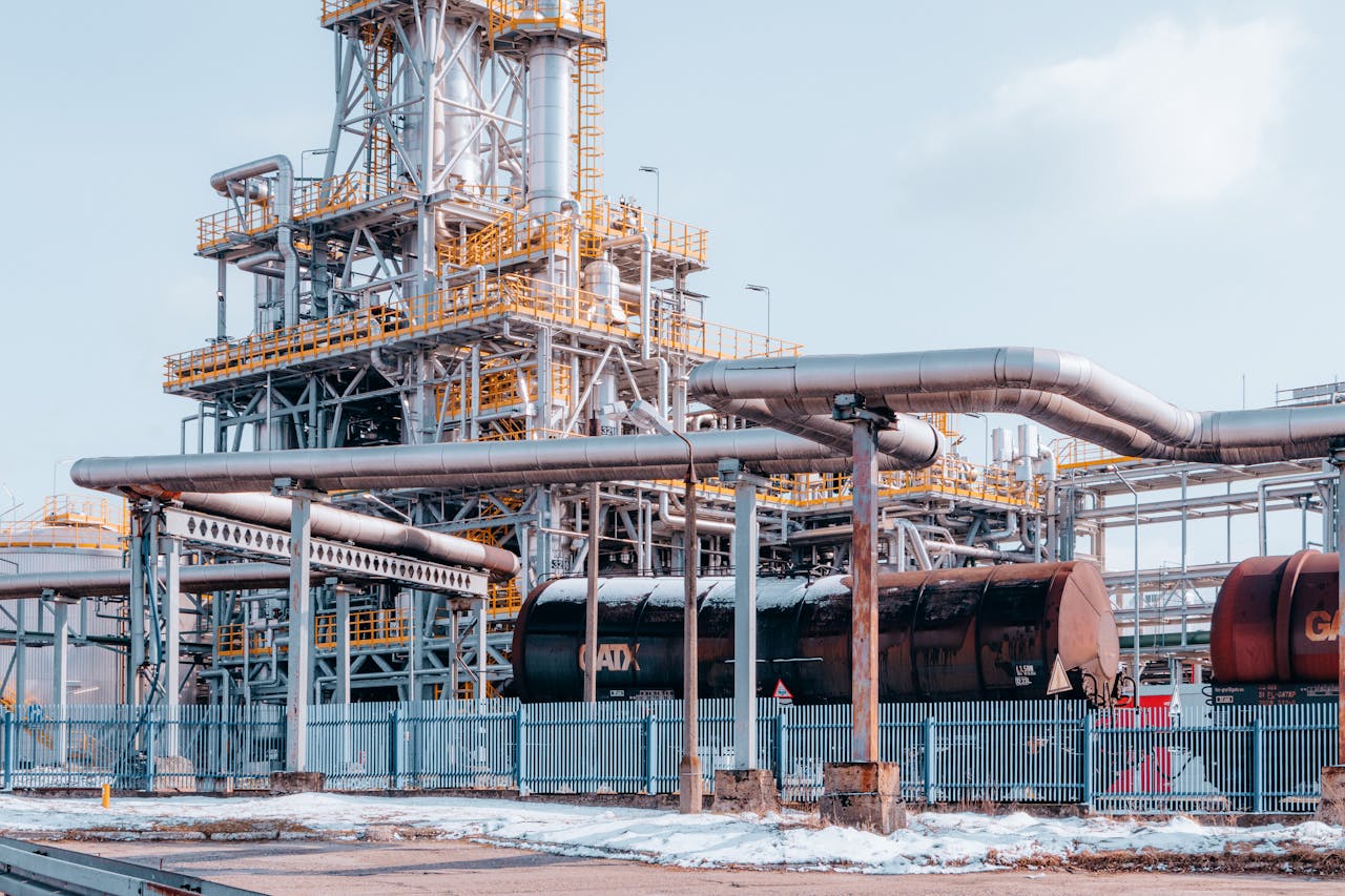 pexels-photo-15970028 Oil refinery facility with tanker wagons in Trzebinia, Lesser Poland Voivodeship under a clear sky.