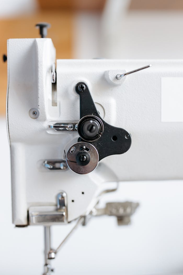 Detailed shot of an industrial sewing machine mechanism showcasing metal parts.