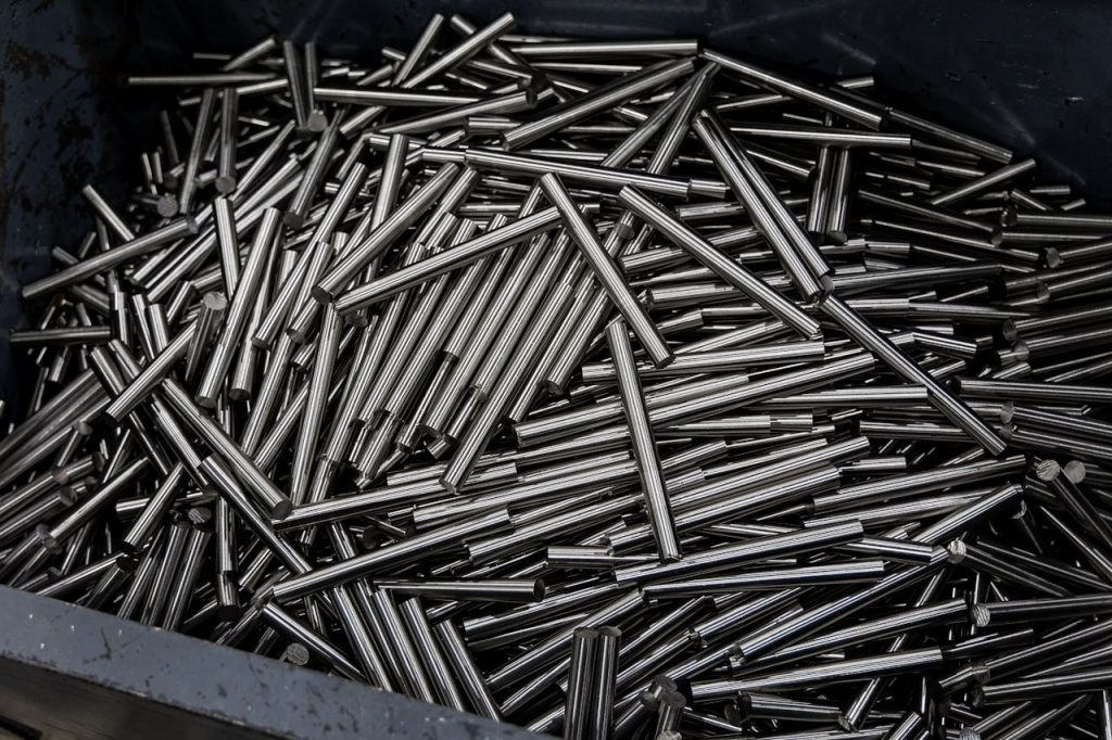 Close-up of numerous stainless steel rods in a container, showcasing industrial metal texture.